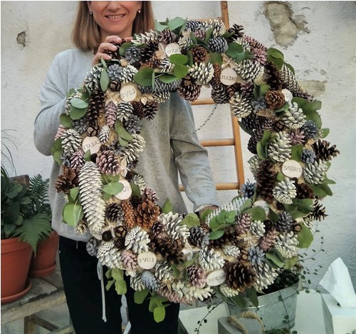 obří věnec z 10ti druhů šišek a motivačními nápisy na dřívkach 